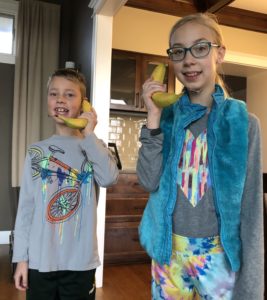 Kids pretending to talk on a banana like a phone
